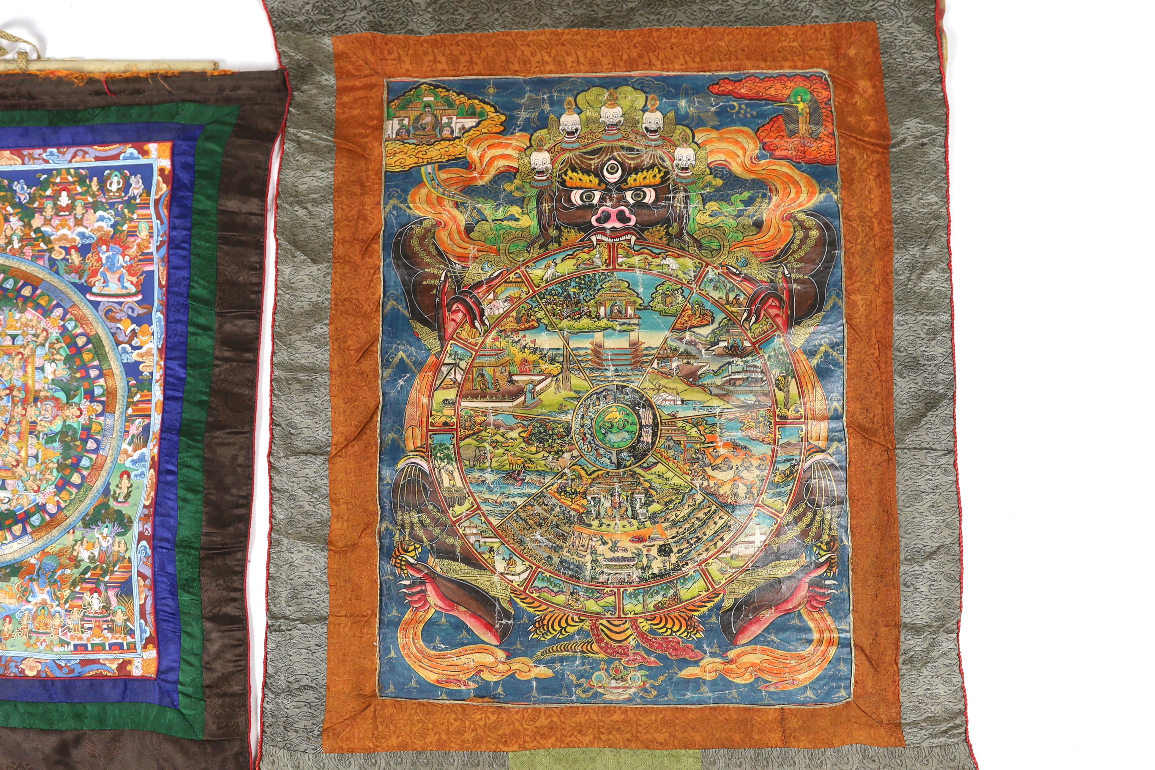 Two Tibetan 20th century Nepalese Thangka and a Burmese Sutra, one Thangka depicting six sections of life, the other a Mandala of Heaven and Earth, 38cm wide, 47cm high (not including silk borders), together with a simpl